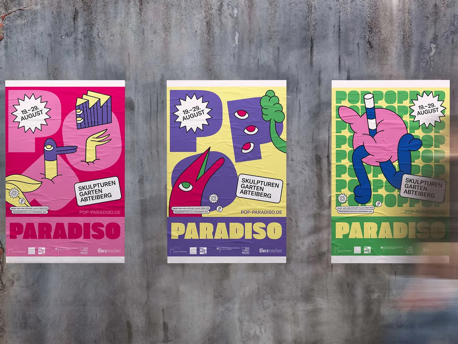 Bunte Festivalplakate von Pop Paradiso mit Illustrationen von Sebastian Jung an einer Betonwand – ein Projekt von Vlip zur urbanen Belebung des öffentlichen Raums in Mönchengladbach.